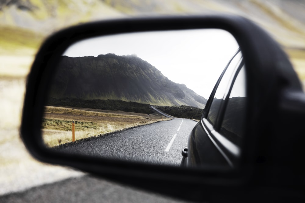 Black wing mirror showing road behind