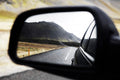 Black wing mirror showing road behind