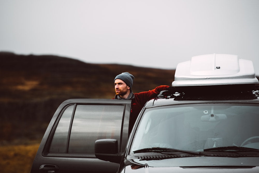 Man standing beside black SUV