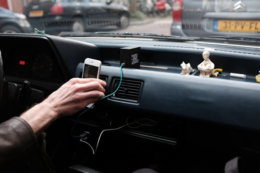 Person holding phone in car with charger