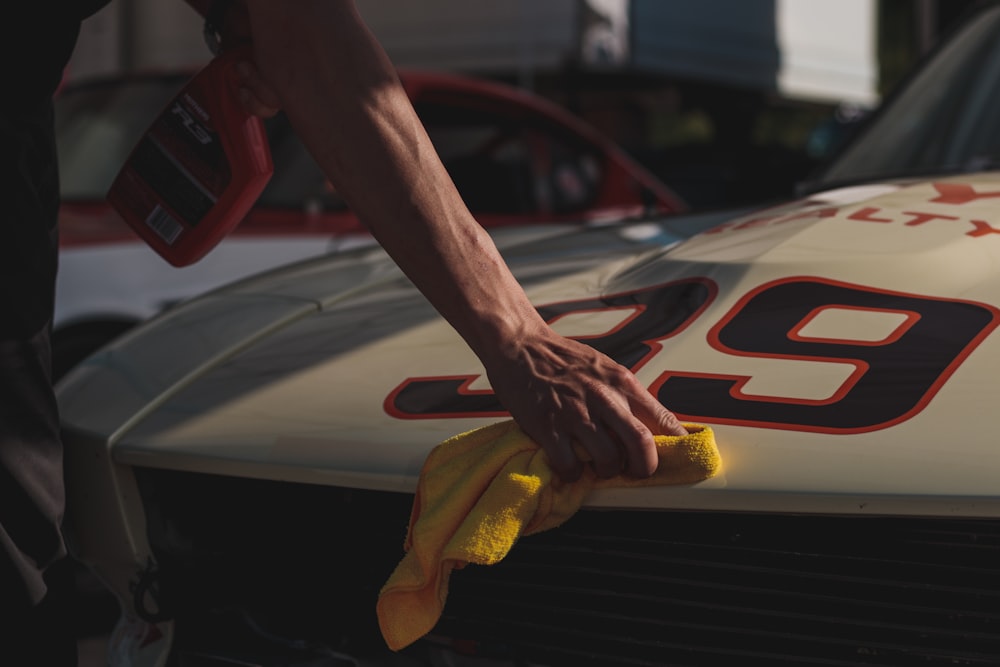 Closeup of person wiping car with cloth