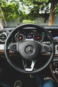 Black Mercedes-Benz steering wheel close up