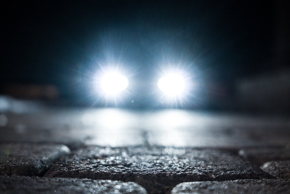 Turned-on vehicle headlight on the street