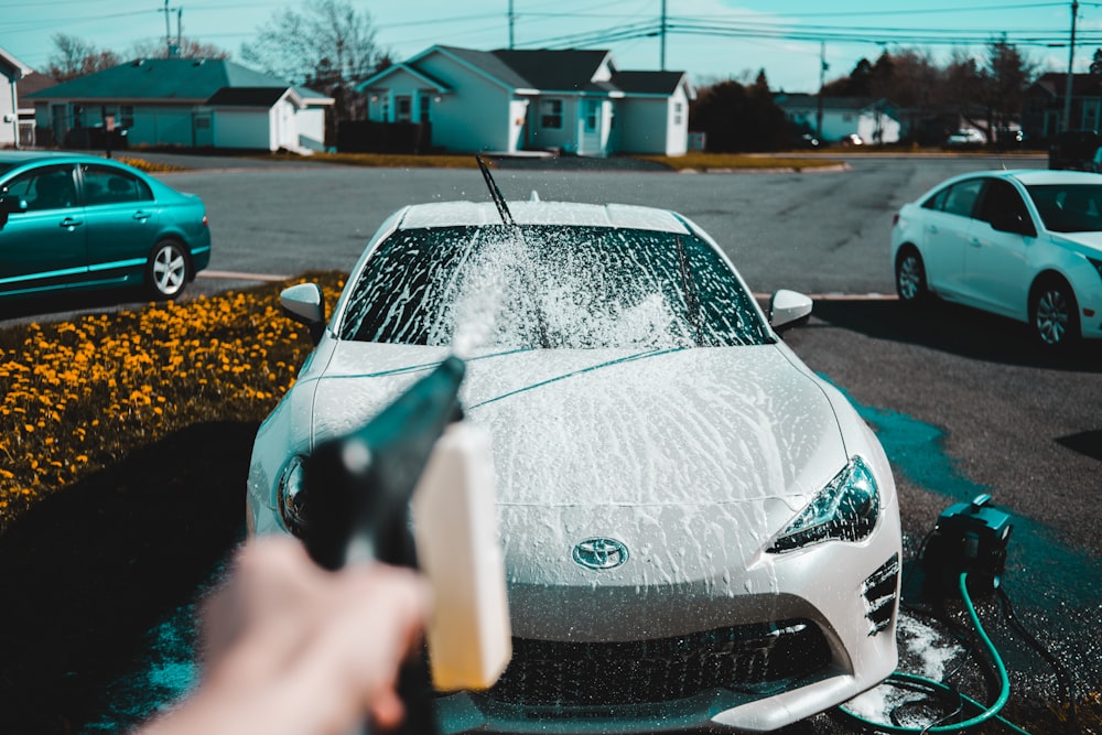 Person spraying cleaner on car