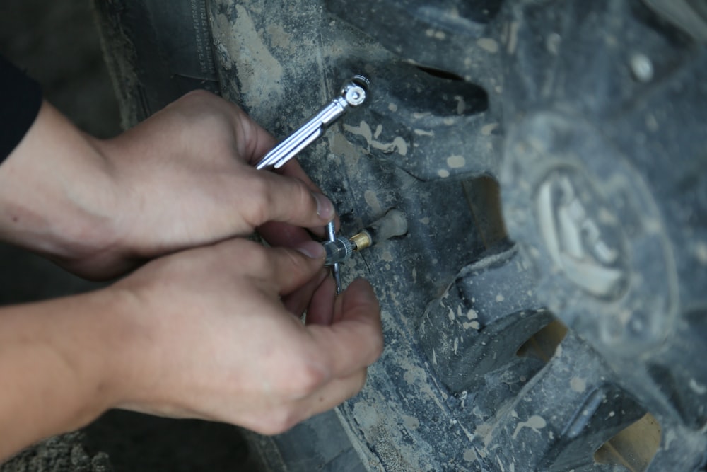 Person checking vehicle tire pressure