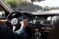 Person holding BMW steering wheel while driving
