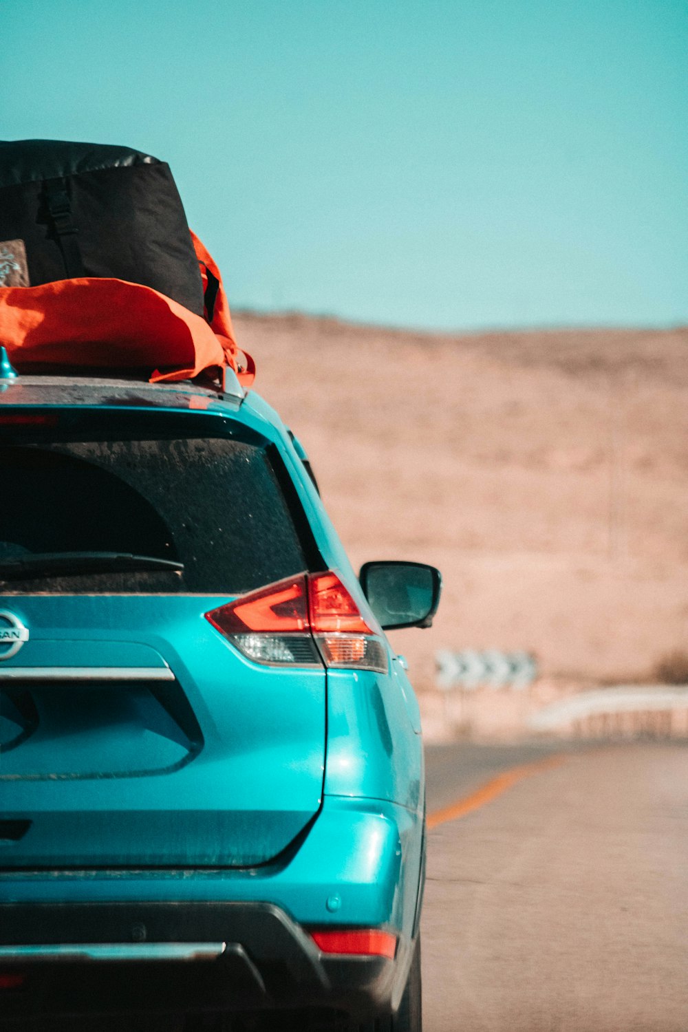 Person standing beside car with rooftop cargo bag
