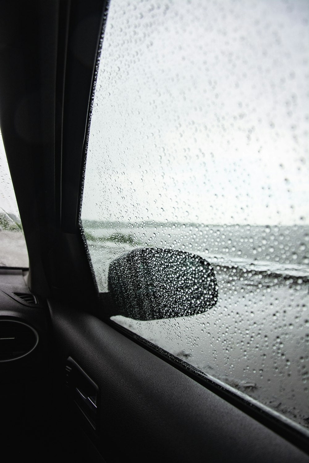 Water beading on car window after repellent treatment