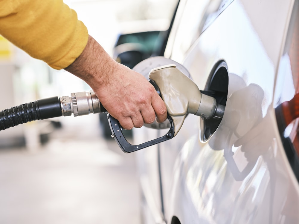 Man pumping gas into car at station