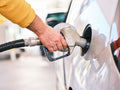 Man pumping gas into car at station