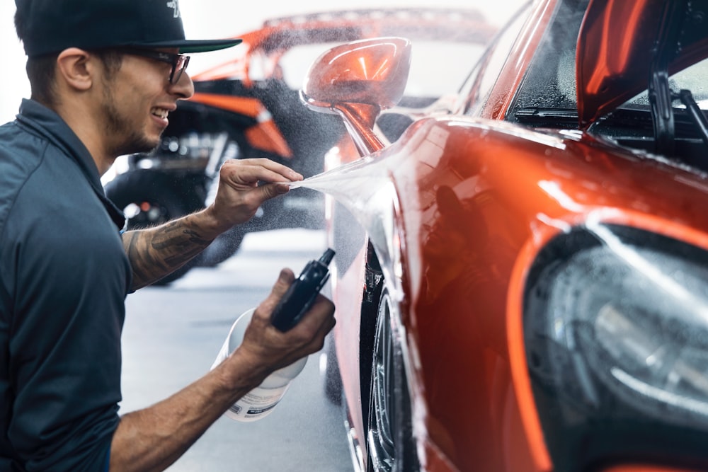 Person applying touch-up paint to car