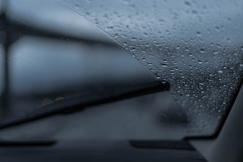 Rain drops on car windshield with wipers