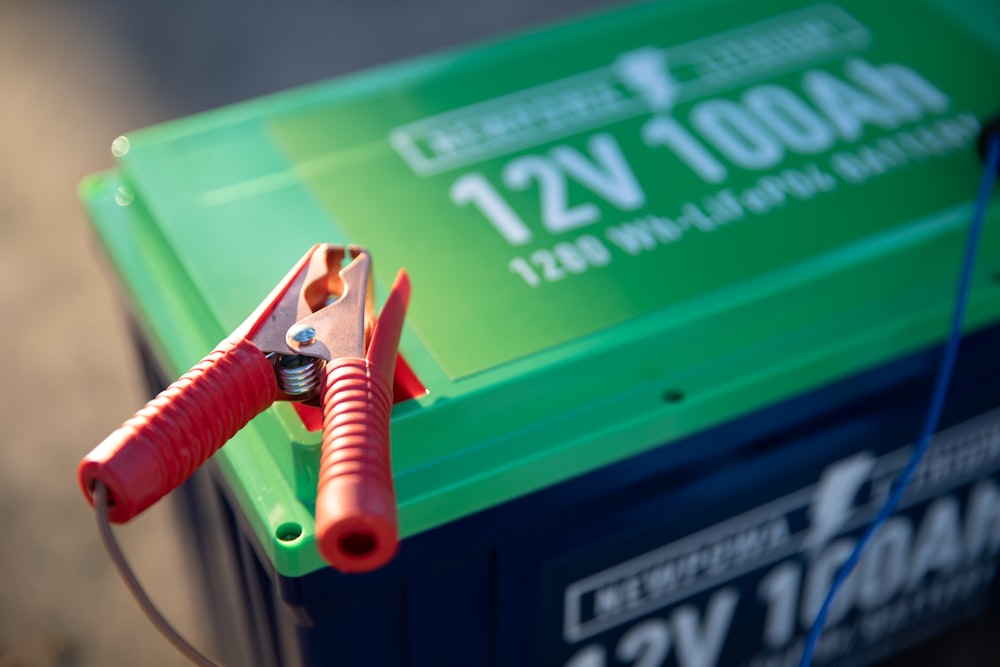 Red and green battery with jumper cable clamps