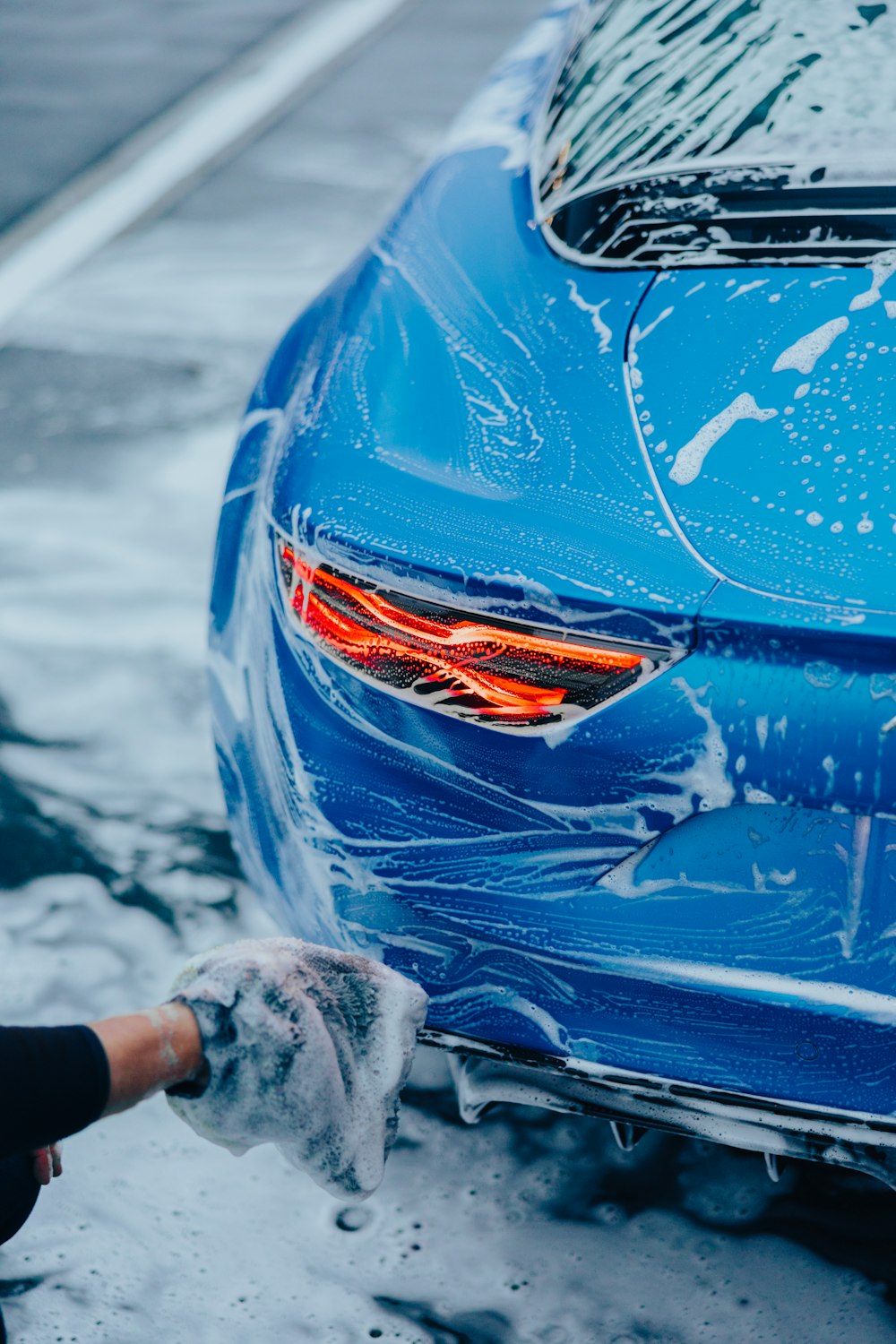 Person detailing car with microfiber cloth