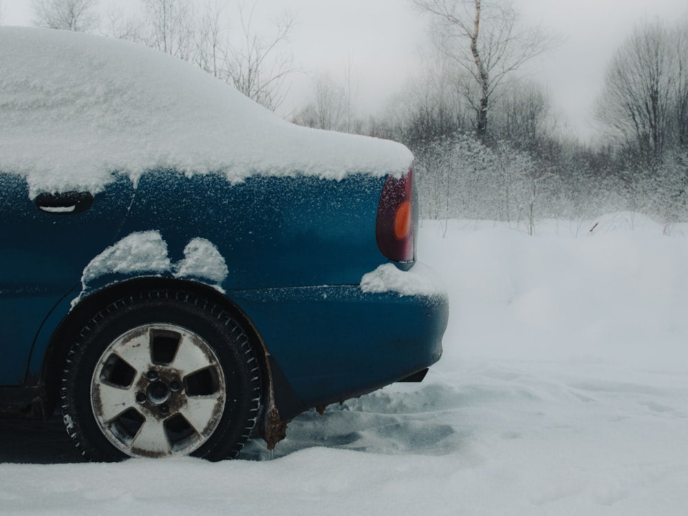 Blue car covered in snow