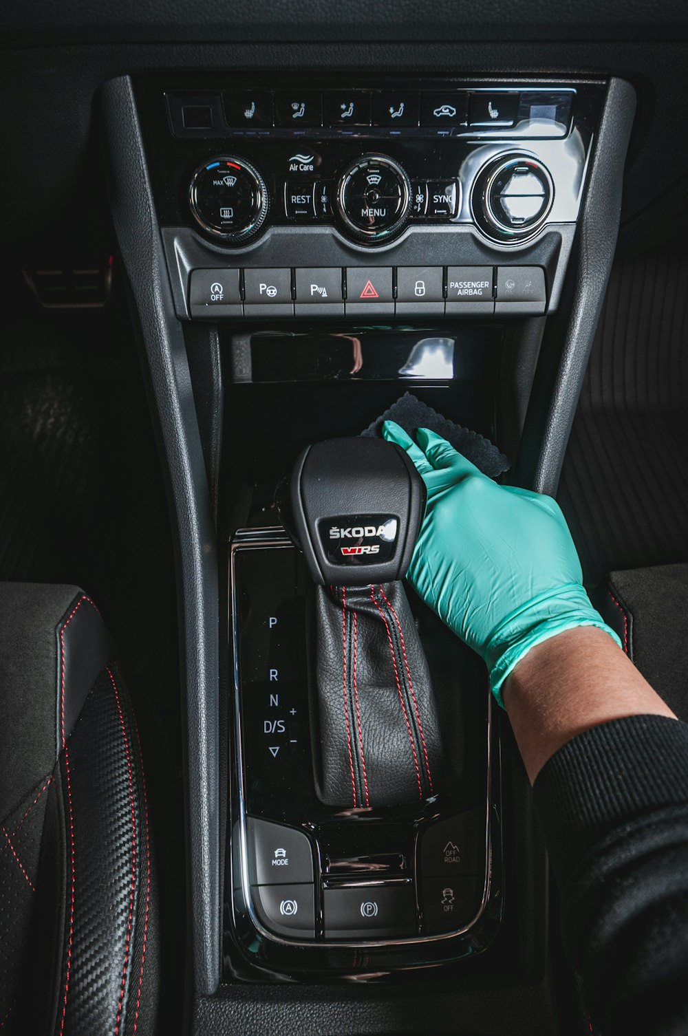 Gloved hand adjusting car radio
