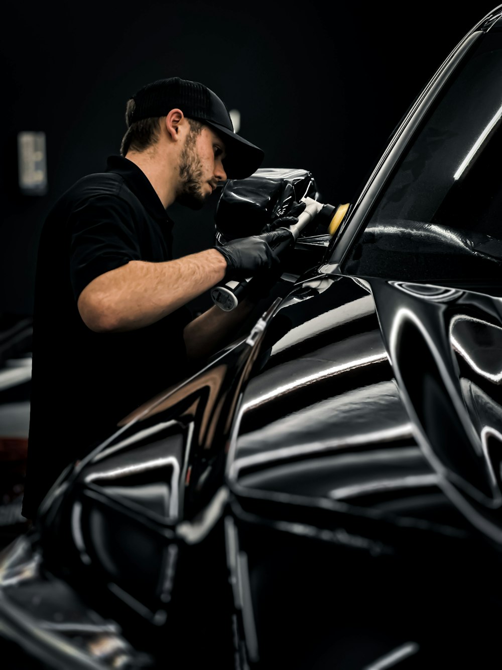 Man waxing and polishing car in garage