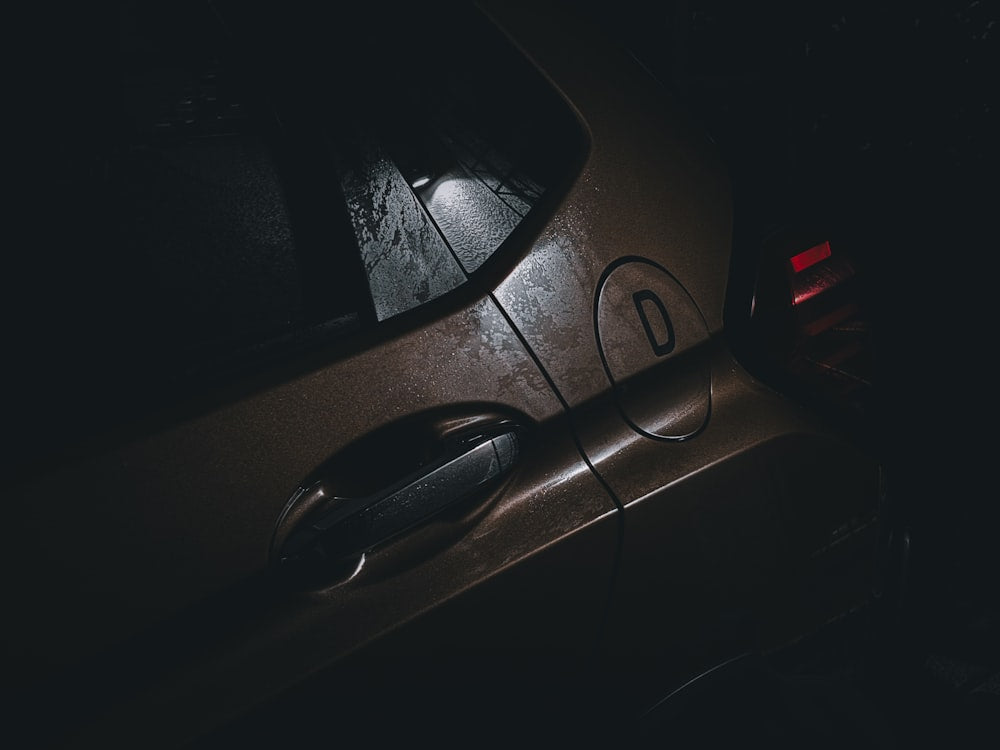 Car parked in dark with door open and lights on