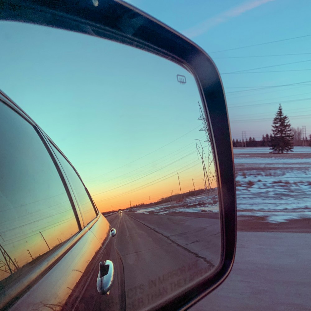 Rear view mirror on a car reflecting sunset