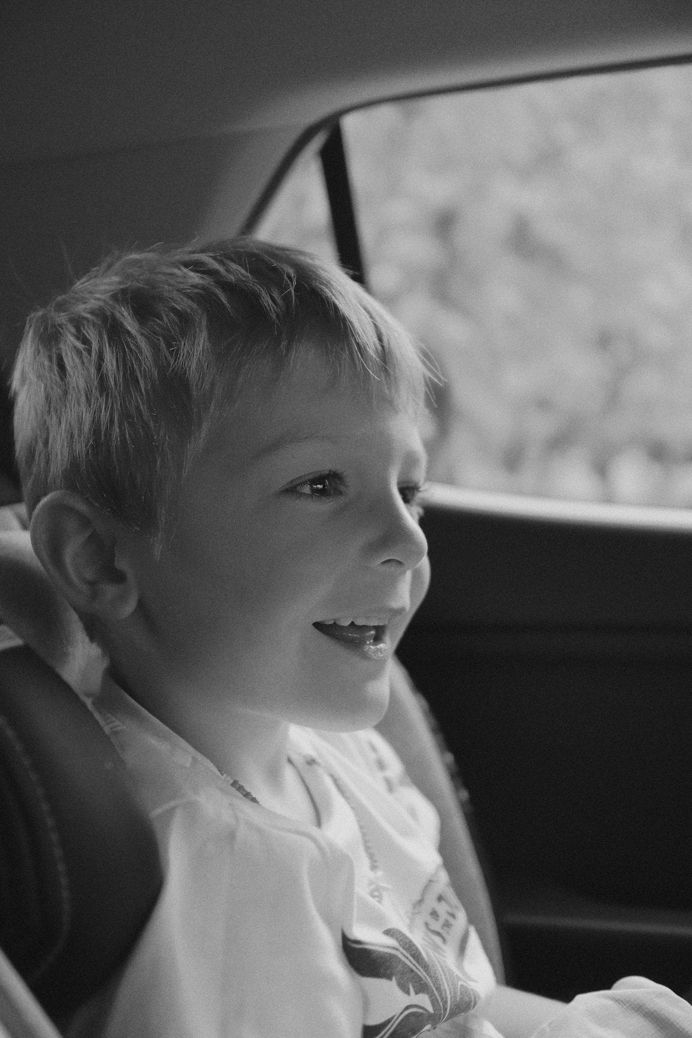 Young boy sitting in the back seat of a car