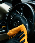 Person cleaning a car with microfiber cloth