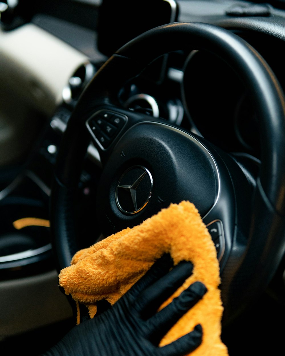 Person cleaning a car with microfiber cloth