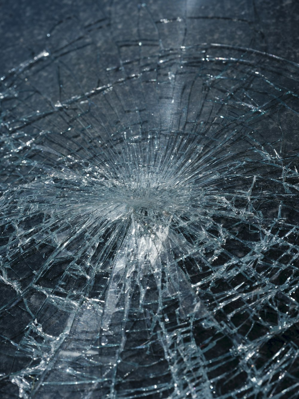 Shattered windshield glass with impact point