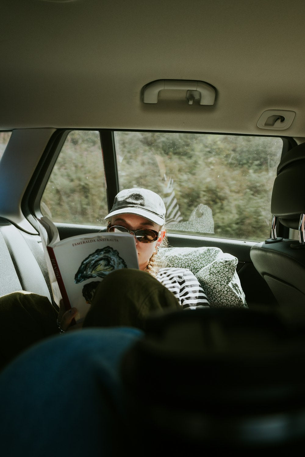 Person in car reading a book during a trip