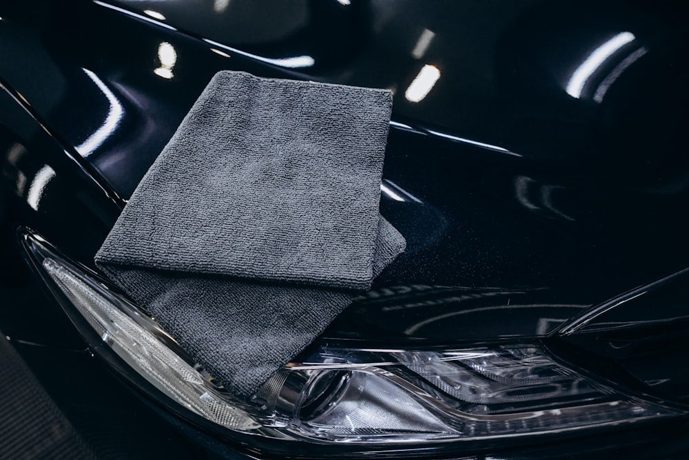 Gray microfiber cloth on a black car hood