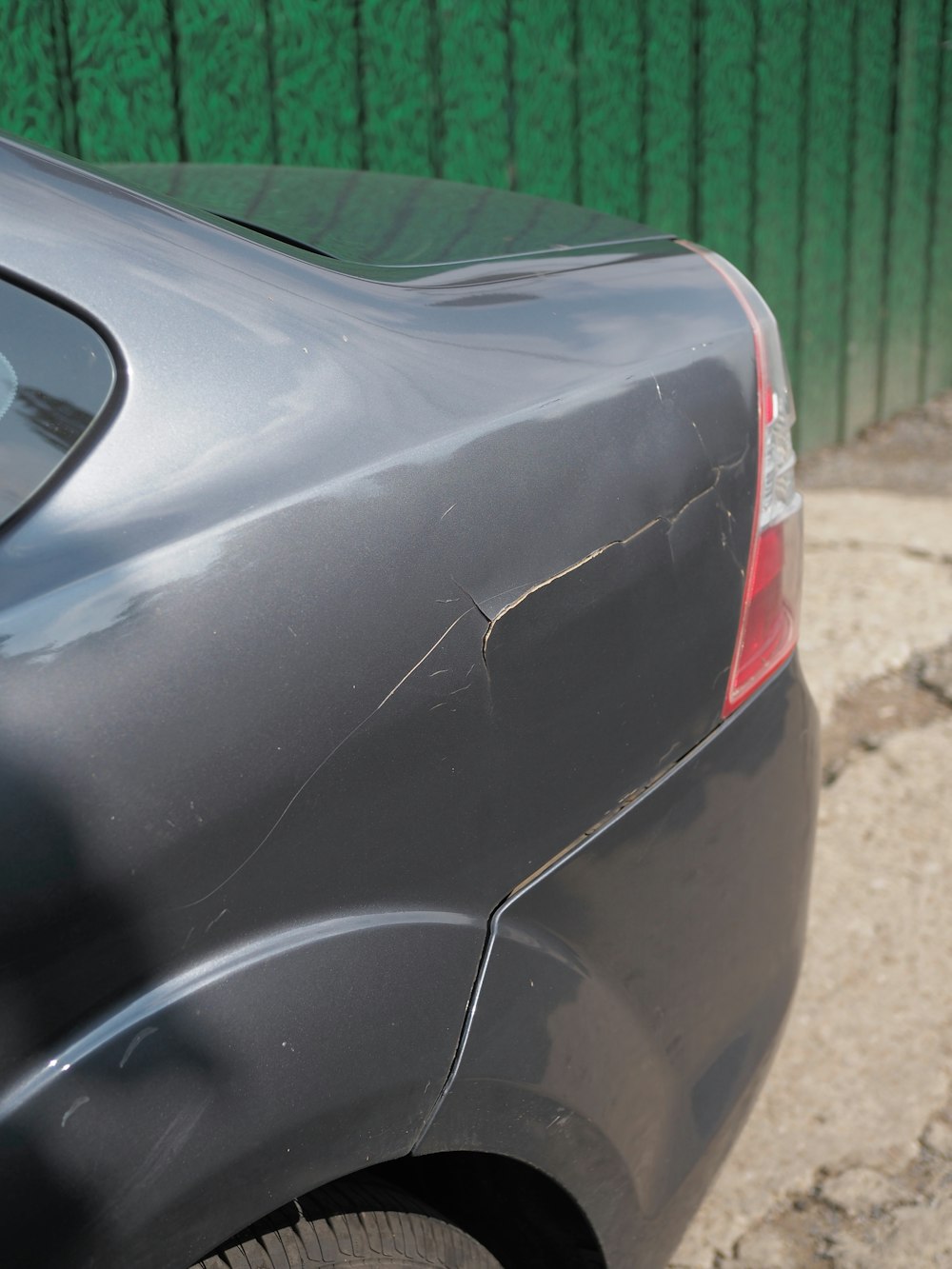 Damaged car fender with cracked paint