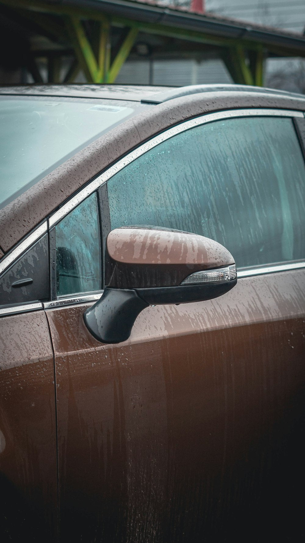 Car door covered in water droplets being cleaned