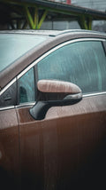 Car door covered in water droplets being cleaned