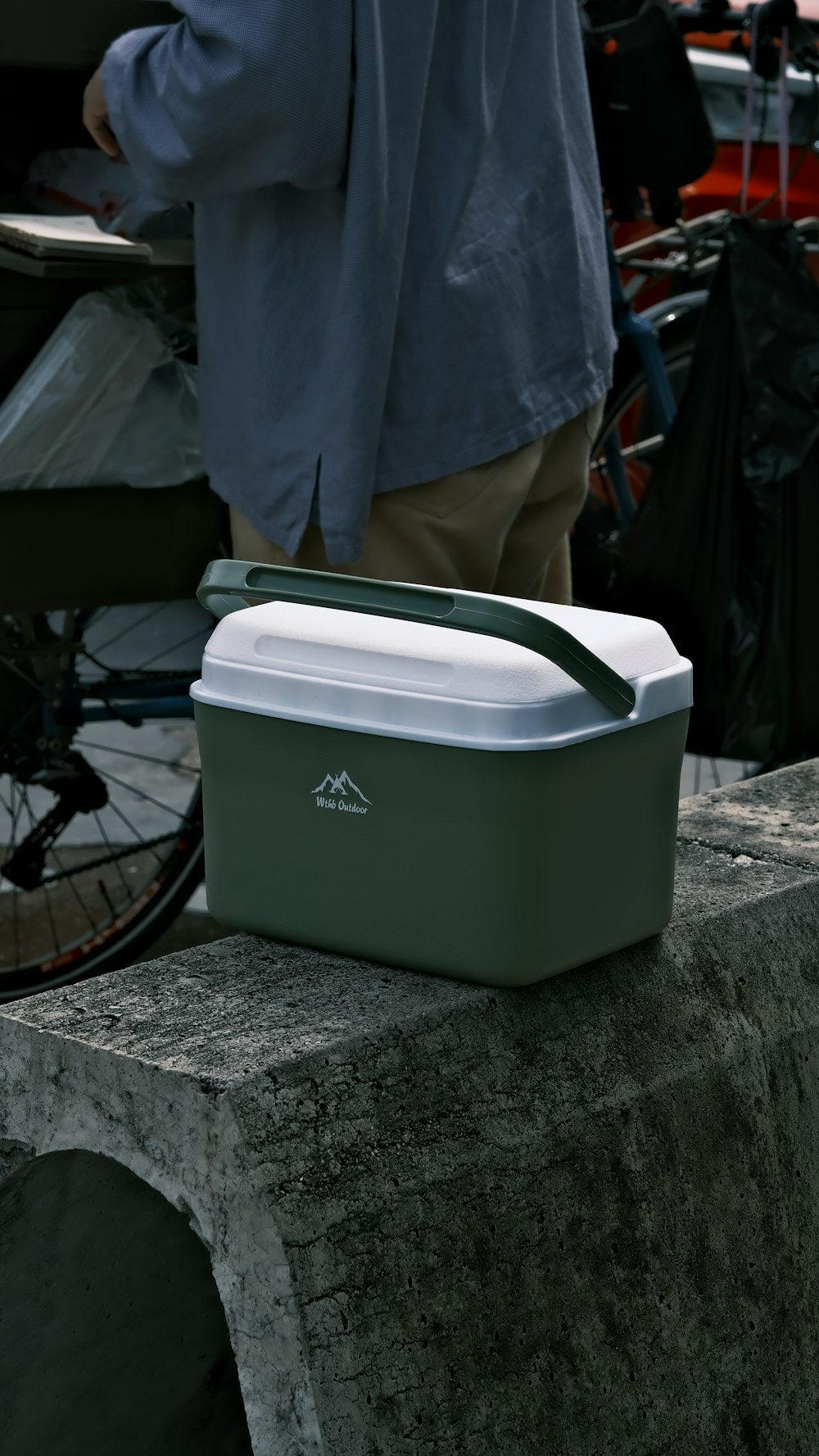 Green and white portable cooler on concrete