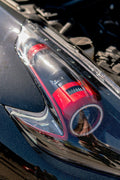 A red car vacuum cleaner on a dark car hood
