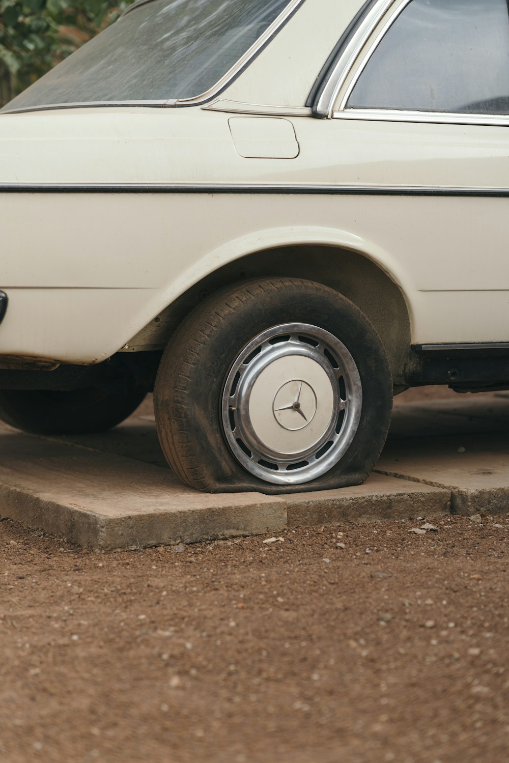 Car with flat tire on dirt road