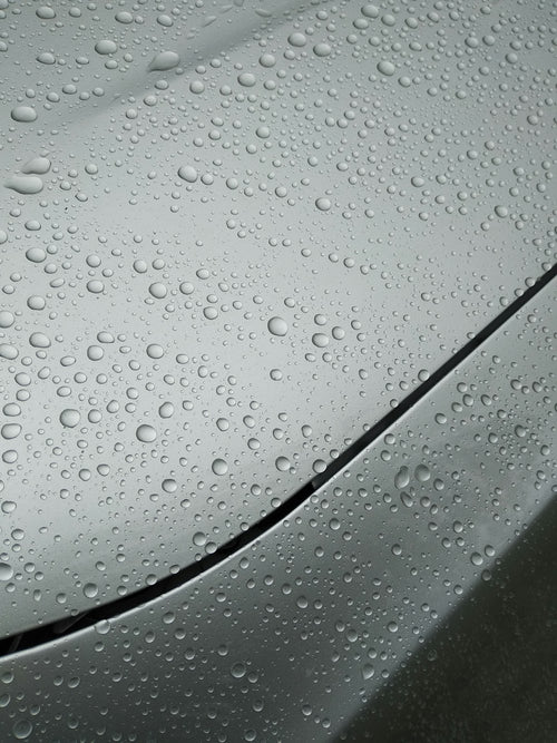 Water droplets on metallic gray car hood