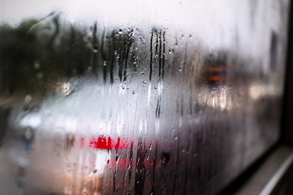 Raindrops streaming down foggy window